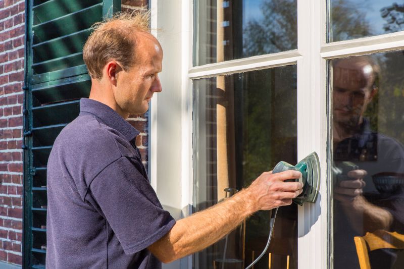 man using electric sander to prepare surface for painting